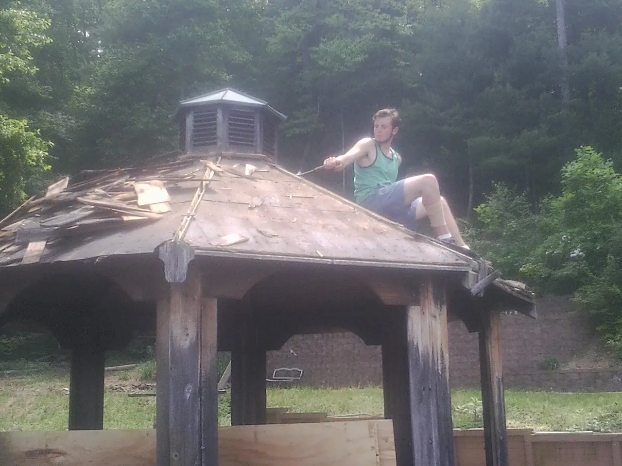 Tearing the old roof off a wooden gazebo before new shakes in Callaway