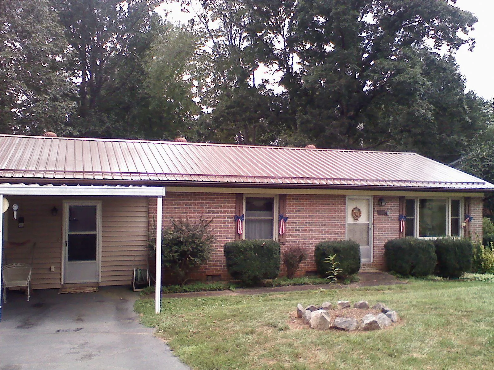 Bronze metal roof and carport on a brick ranch home — Roof Repair work by our crew in Callaway